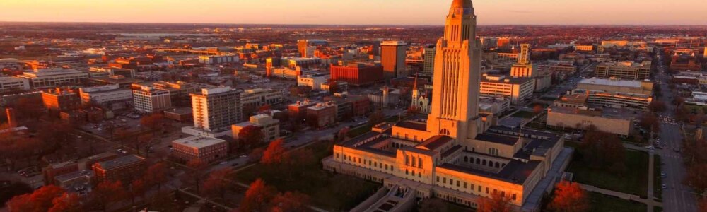 The Lincoln, Nebraska cityscape at sunrise. The State Capitol stands out among all the other buildings downtown.